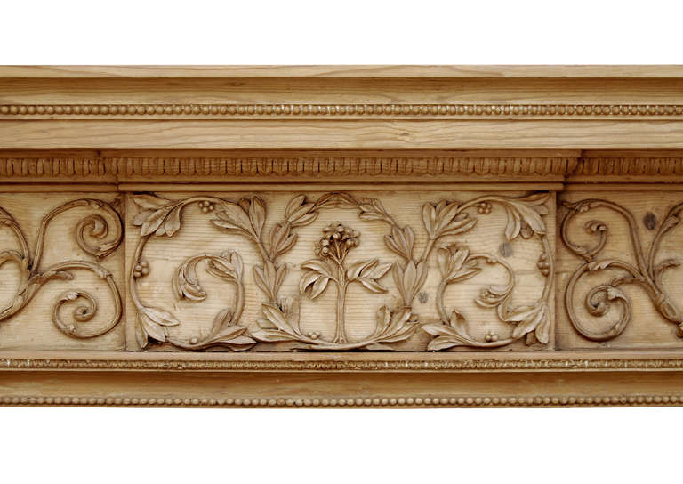An attractive 18th century George III pine fireplace. The frieze delicately carved with scrolled foliage to centre blocking and side panels. The jambs with carved tied ribbon with bellflower drops below. Leaf and pearl mouldings to opening, and