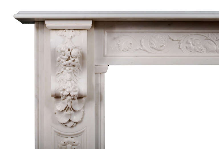 An early Victorian English statuary marble fireplace. The panelled jambs with carved flowers and foliage throughout with elaborately carved corbels above. The panelled frieze with scrolled leaf work throughout, surmounted by moulded shelf. Very good
