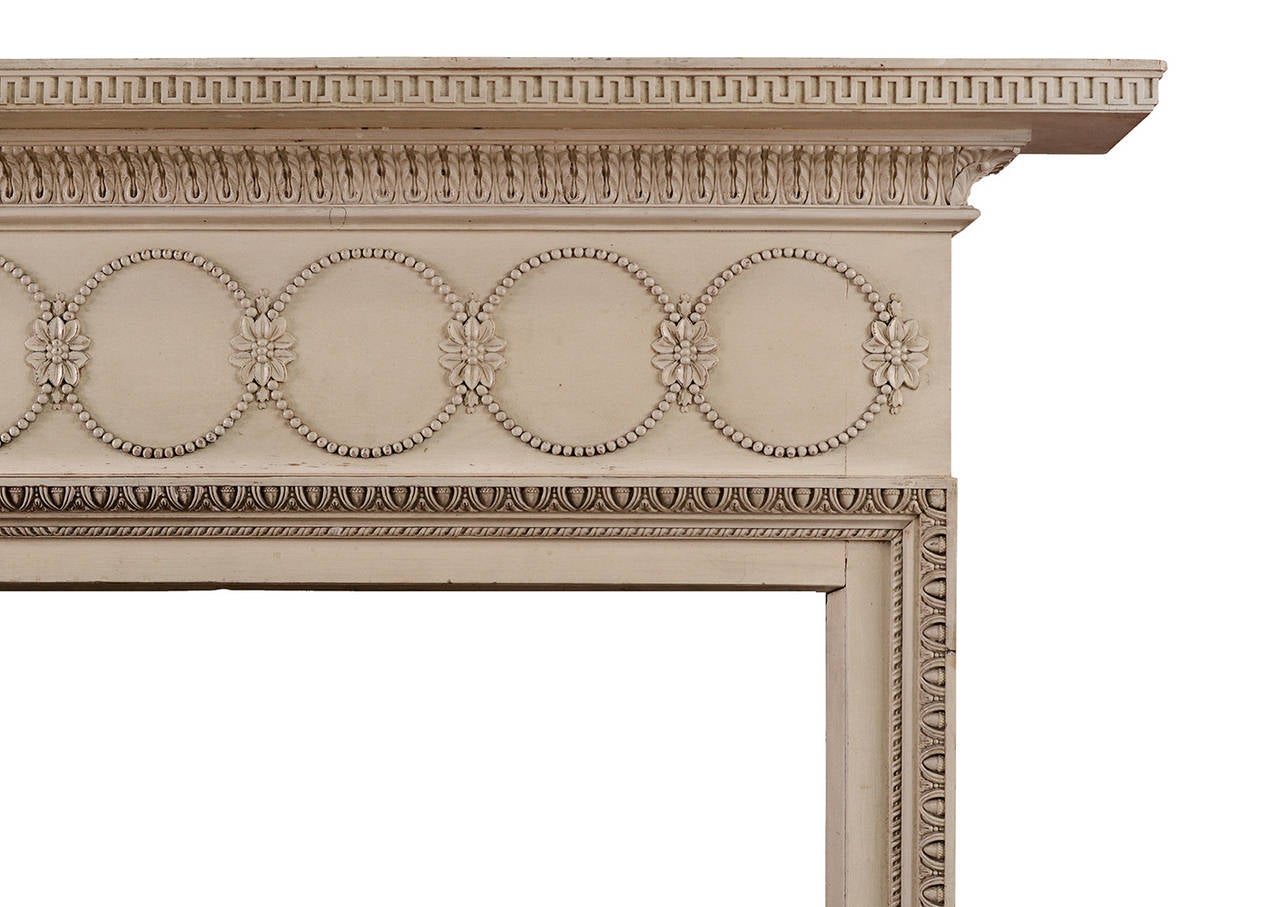 A very pretty painted timber fireplace with particularly fine detailing. The frieze with ring pattern interspersed with flowers, the inner moulding of unusual acorn and bellflower design, rope moulding to inside of jambs, Greek key and water leaf