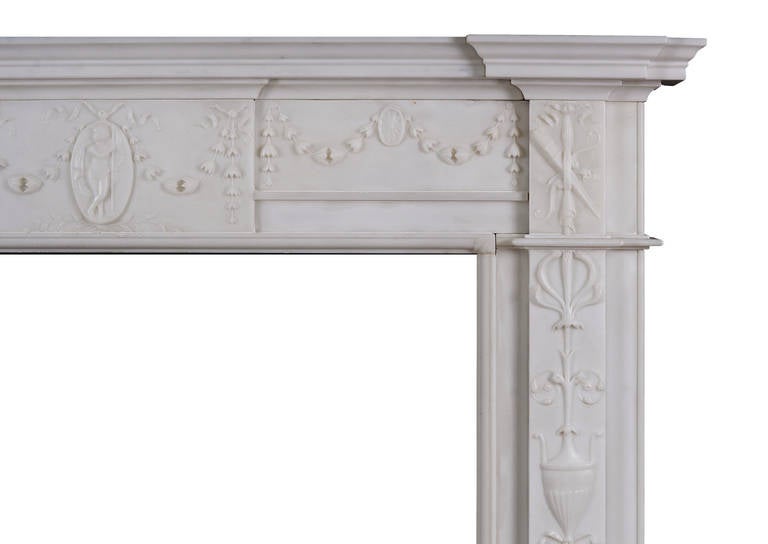 A George III style statuary marble fireplace. The design in the manner of Robert Adam with fine carving to frieze and jambs. The frieze with bellflower swags and paterae, the centre tablet with a cameo of Mercury, the messanger of the Roman gods