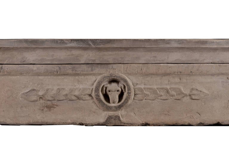A rustic, early 18th century carved stone fireplace mantel