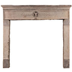 A rustic, early 18th century carved stone fireplace mantel