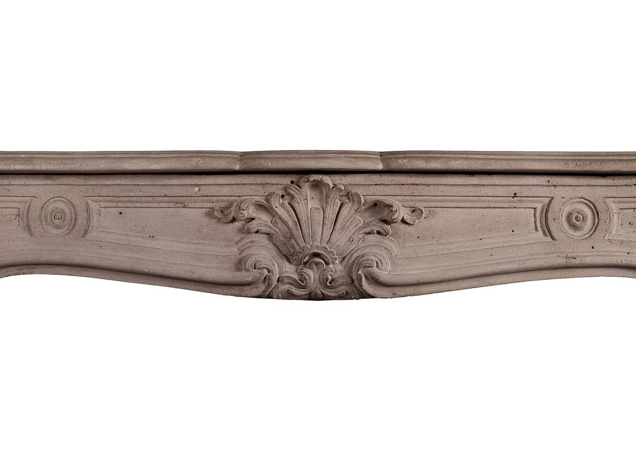 A French Louis XV antique stone fireplace. The tapering, stop-fluted jambs with shaped panel above. The frieze with carved cartouche to centre and scrolled design to ends, late 18th-early 19th century.

Measurements:
Shelf width - 1475 mm / 58 1/8