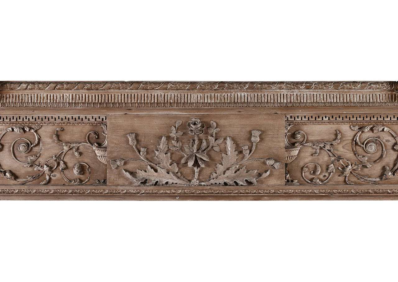A fine quality 18th century carved pine and lime fireplace in the manner of Robert Adam. The frieze with centre plaque of flowers and foliage, juxtaposed by a demi-urn and scrolled foliage, and carved side blockings with classical urns. The shelf