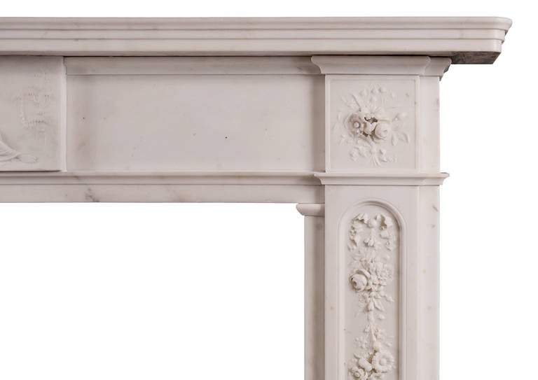A good quality period Regency statuary marble fireplace. The panelled jambs with finely carved cascading ribbons, flowers and foliage, surmounted by end blockings of tied flowers. The frieze with carved centre featuring reclining classical figure.