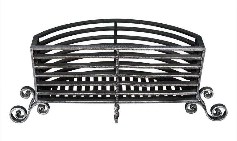 A large polished wrought iron fire grate. The flat front with rounded burning area behind and scrolled feet below. Suitable for a large burning area, would accept large logs.

Width At Front:	1100 mm      	43 ¼