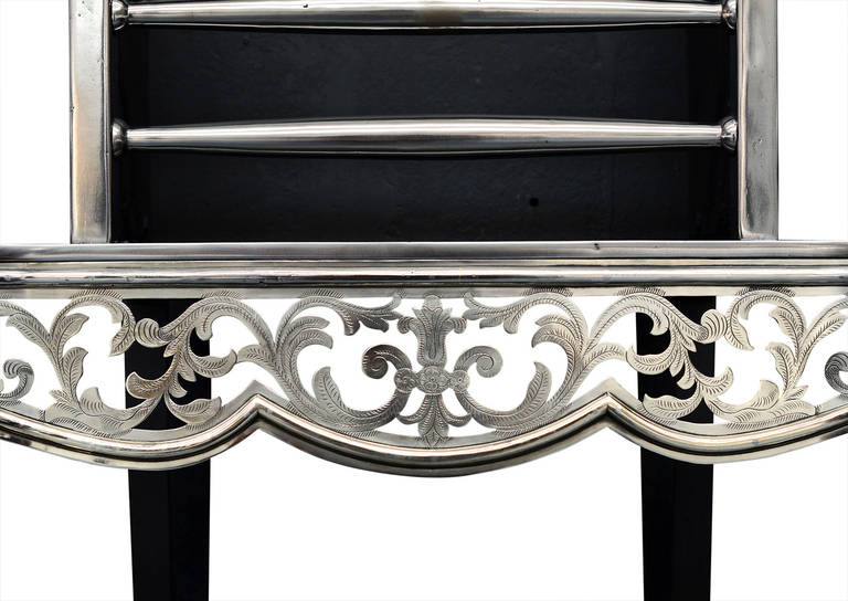 An attractive steel and nickel fire grate, in the mid-Georgian style, the pierced and engraved fretwork of floral pattern, tapering column legs with bulbous urn finials. The fretwork, legs and finials in nickel with polished steel front bars and