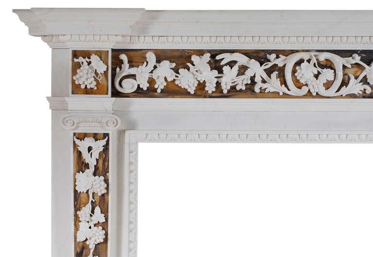 A very good quality English George II white marble fireplace with Siena inlay. The frieze finely carved with grapes, foliage and wheat sheafs surmounted by breakfront shelf with leaf moudling. The tapering jambs with carved drops of foliage and