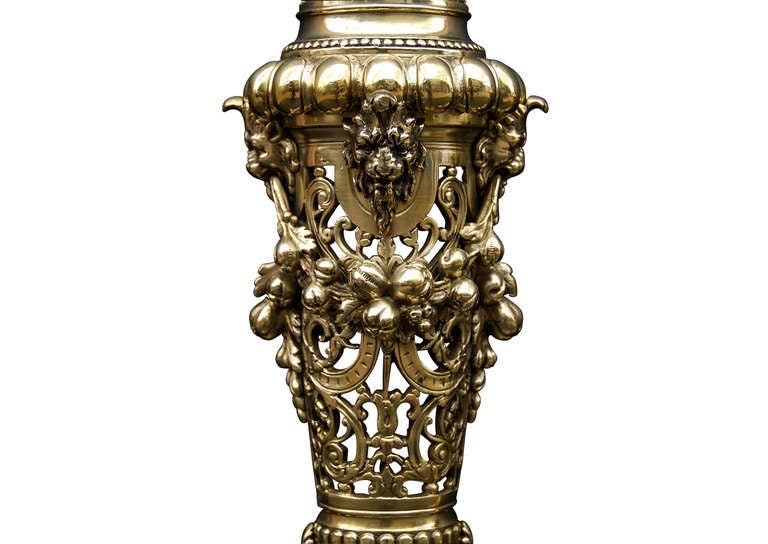 A fine quality pair of cast brass chenets. The pierced feet with cherubs to centre surmounted by trophy urns and repousse finial. English, 19th century. (Back bars could be added to accept basket if required)

Measures: 
Height:	585 mm      	23