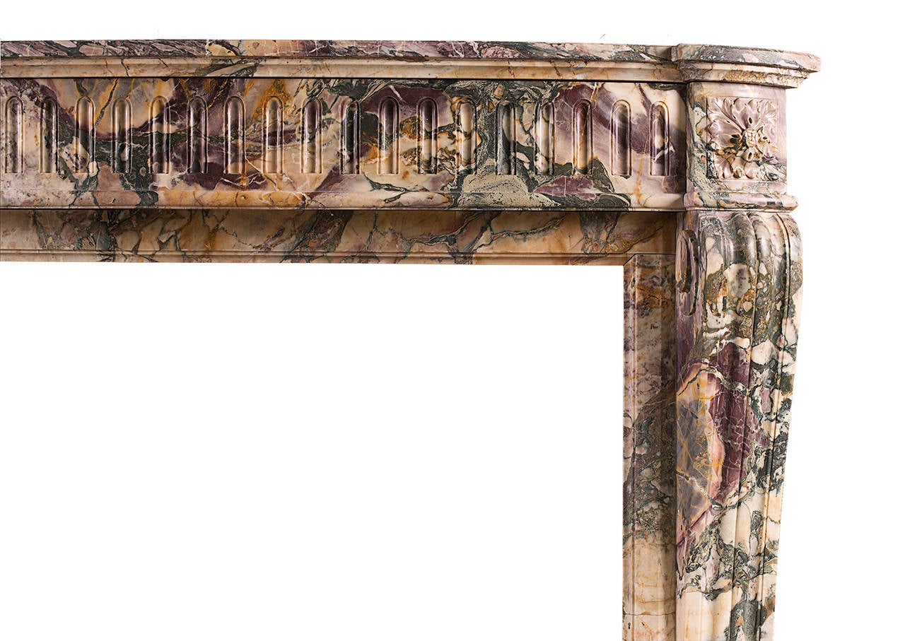 A 19th century French Louis XVI style Breche de Benou marble mantel piece. The shaped, scrolled jambs with carved square paterae above. The bowed frieze with flutes throughout and shaped, moulded shelf above. A very rare, striking marble from the