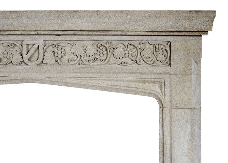 An English stone fireplace in the Gothic style. The carved frieze with foliage, fruit and shield to centre with spandrels below, the plain legs with moulding ingrounds. Moulded shelf. circa 1900.

Measures: Shelf length - 57.25 in / 1454