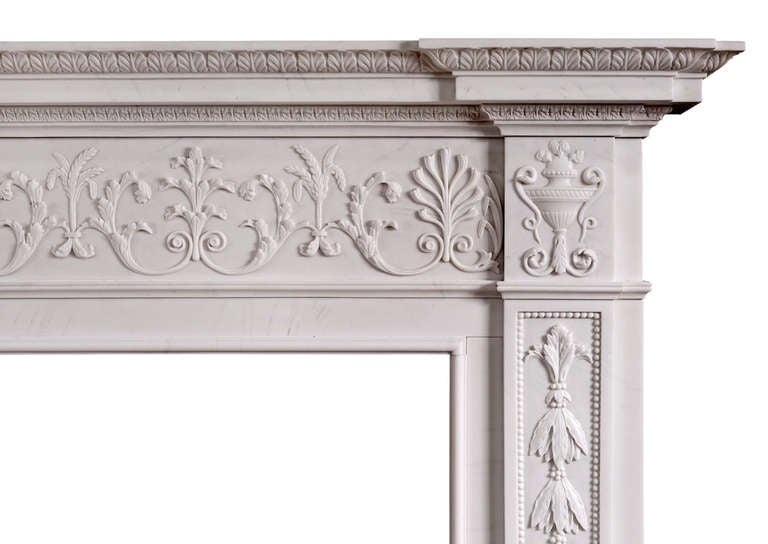A very fine George III style white marble fireplace. The jambs with carved laurel leaves interspersed with berries inside beaded panels, surmounted by scrolled urn side blockings. The delicately carved frieze with draped urn centre, sheaths of