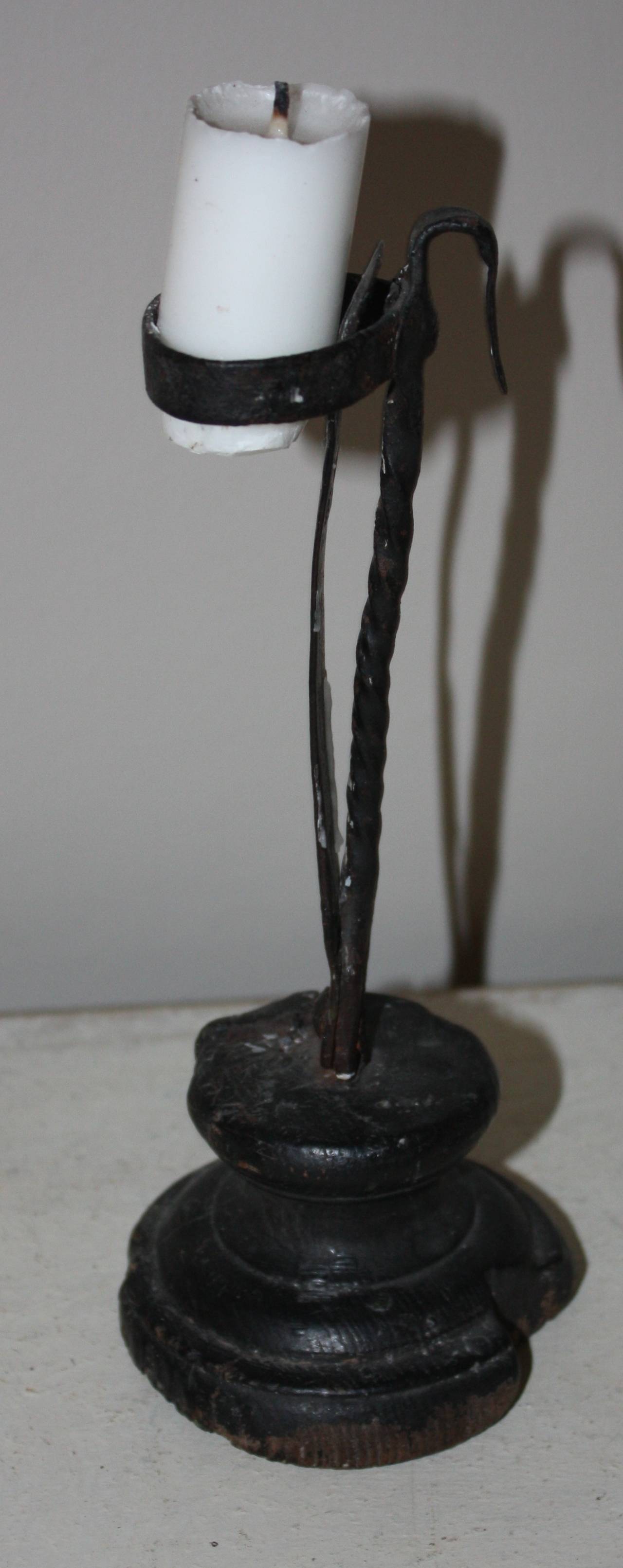 Adjustable wrought iron and wood candle holder with wood base and snipe nail.