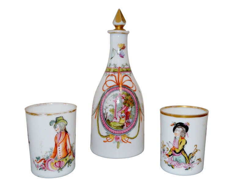 Very beautiful opaline carafe and pair of beakers with very nice motives in beautiful colors and gilded rims and plug.