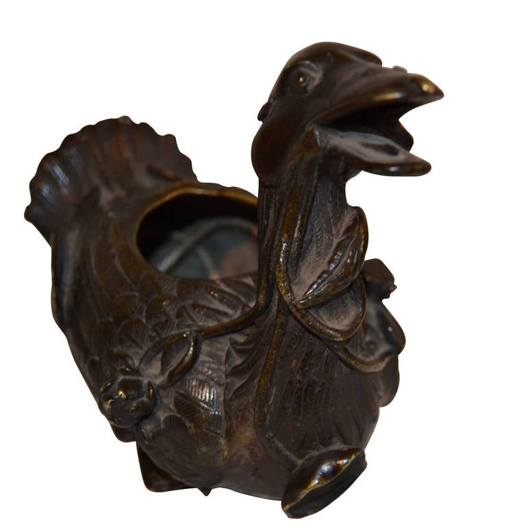 Very beautifull bronze duck with water lilies in it's mouth. Could have been made to contain something viewing the hole on it's back. Might have had a loose lid once, loose since there's no henches for one, on it. And one foot is broken off.