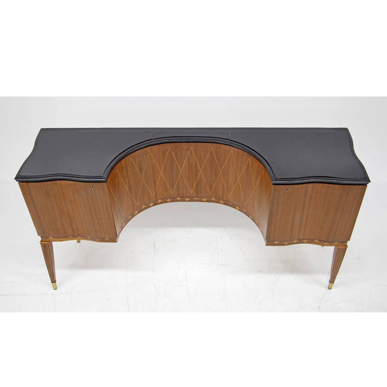 Exceptional Sideboard attributed to Paolo Buffa, Italy ca. 1950
The sideboard is made out of walnut with a concavely curved middle section. It stands on tapered square legs with brass feet and has a compartment with a lockable door on each side.