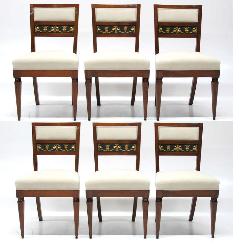 Beautiful set of six Italian Biedermeier chairs with finely carved and gilt ornaments in the back. The chairs are in an excellent original condition. New upholstery with very fine fabric.