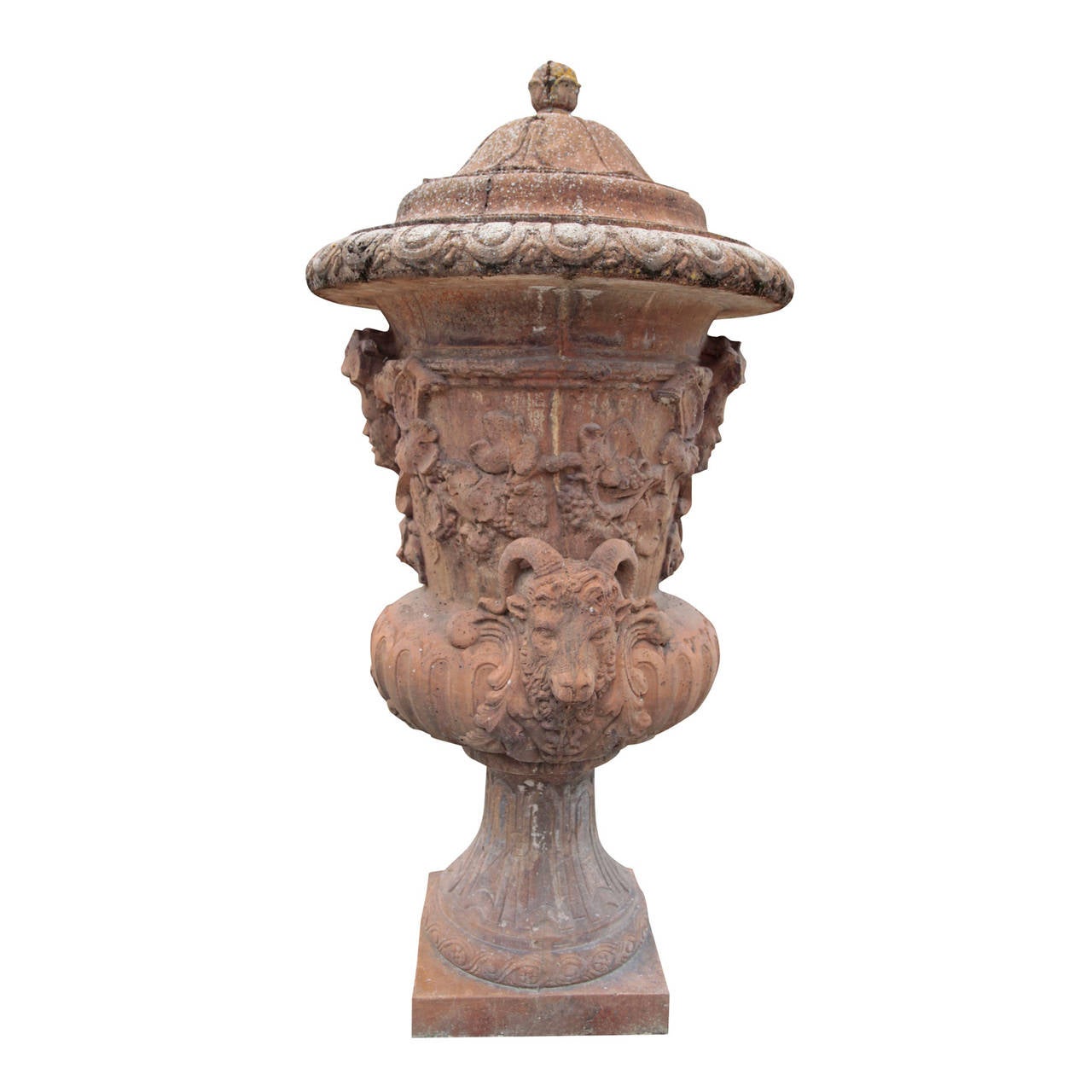 The urn stands on a square plinth. The foot and belly are fluted, while the body is decorated with plastically formed, Dionysian décor. The top lip is decorated with a cymatium and a bell-shaped lid with a small knop.