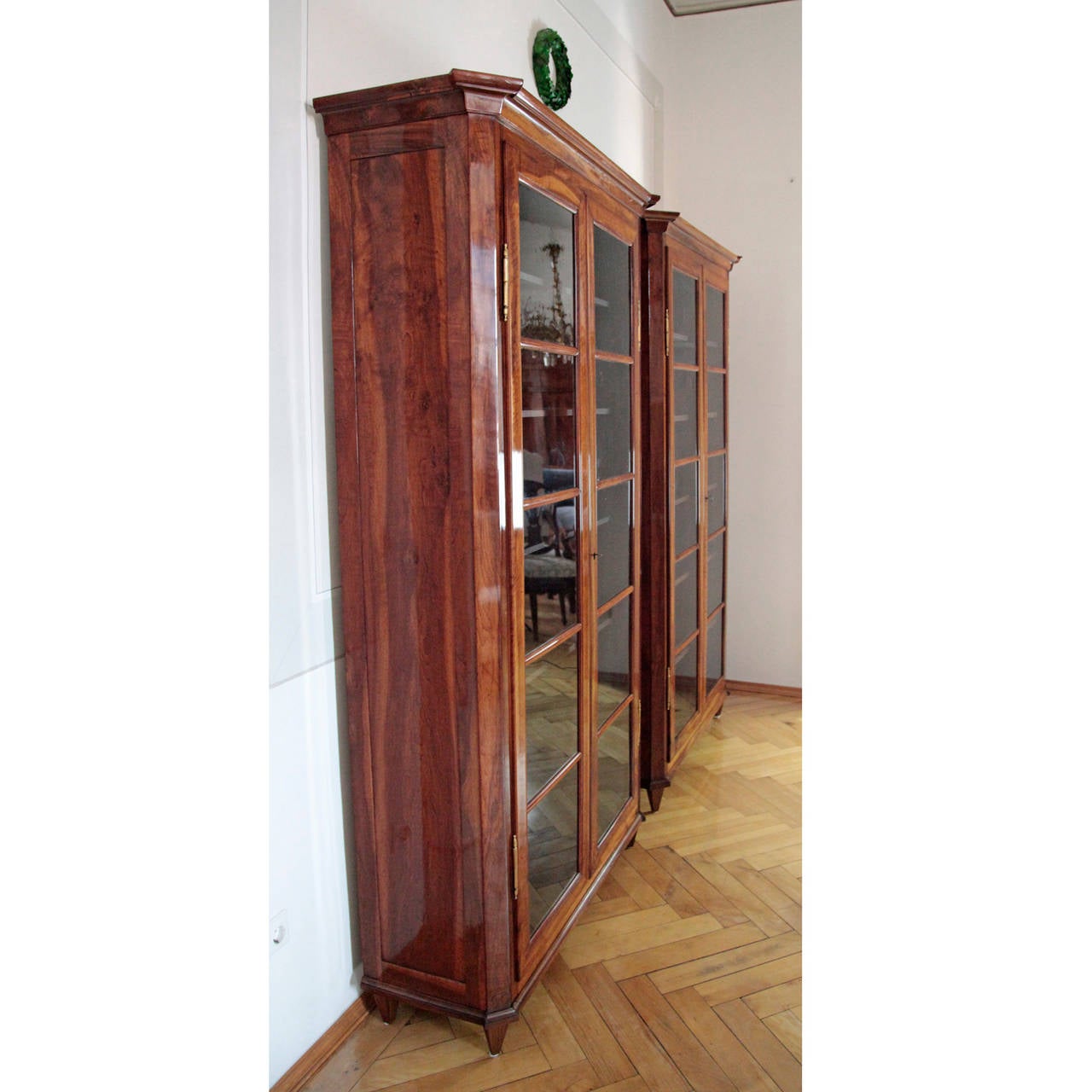 Elegant Pair of German Biedermeier Bookcases from the 1820s. 
The two walnut bookcases stand on four tapered square feet and are glazed at the front. The front corners are slanted, the lower rim and upper edge slightly protrude and are profiled.