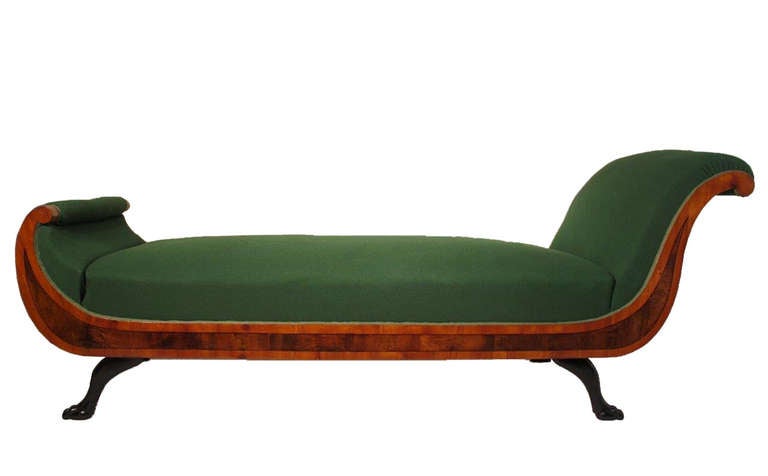 Unique early Biedermeier chaise longue from around 1815 with decorative ebonized sculptured paw legs and C-volute shaped stylized cherry wood veneer with yew wood fielding frame. The elegant Chaise Longue is originally from the Residenz Eichstätt in