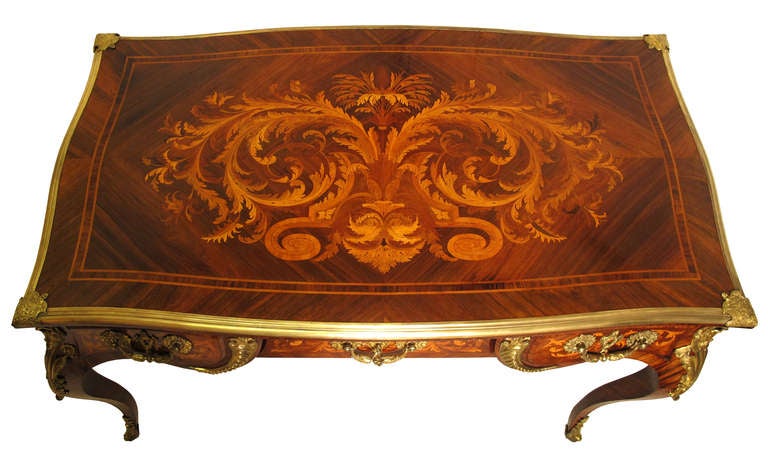 Very elegant French Louis XV style Rococo Bureau Plat dating from the second half of the 19th century after the ideals of the great Parisian Ébénistes of the 18th century.  The high quality crafted curved rosewood veneered frame is made from maple,