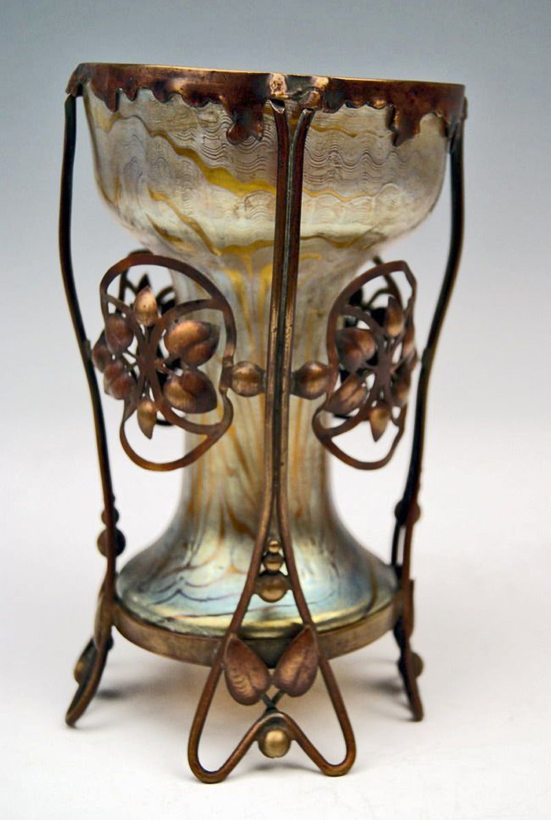Made by Loetz, Klostermuehle   (Bohemia)     circa  1900
Decor:  Phaenomen Genre  7506,  with gorgeous copper fittings  

Vase Loetz   (Lötz)   Widow  Klostermuehle Bohemia Art Nouveau 

Outstanding Loetz Vase of museum quality:  
Golden