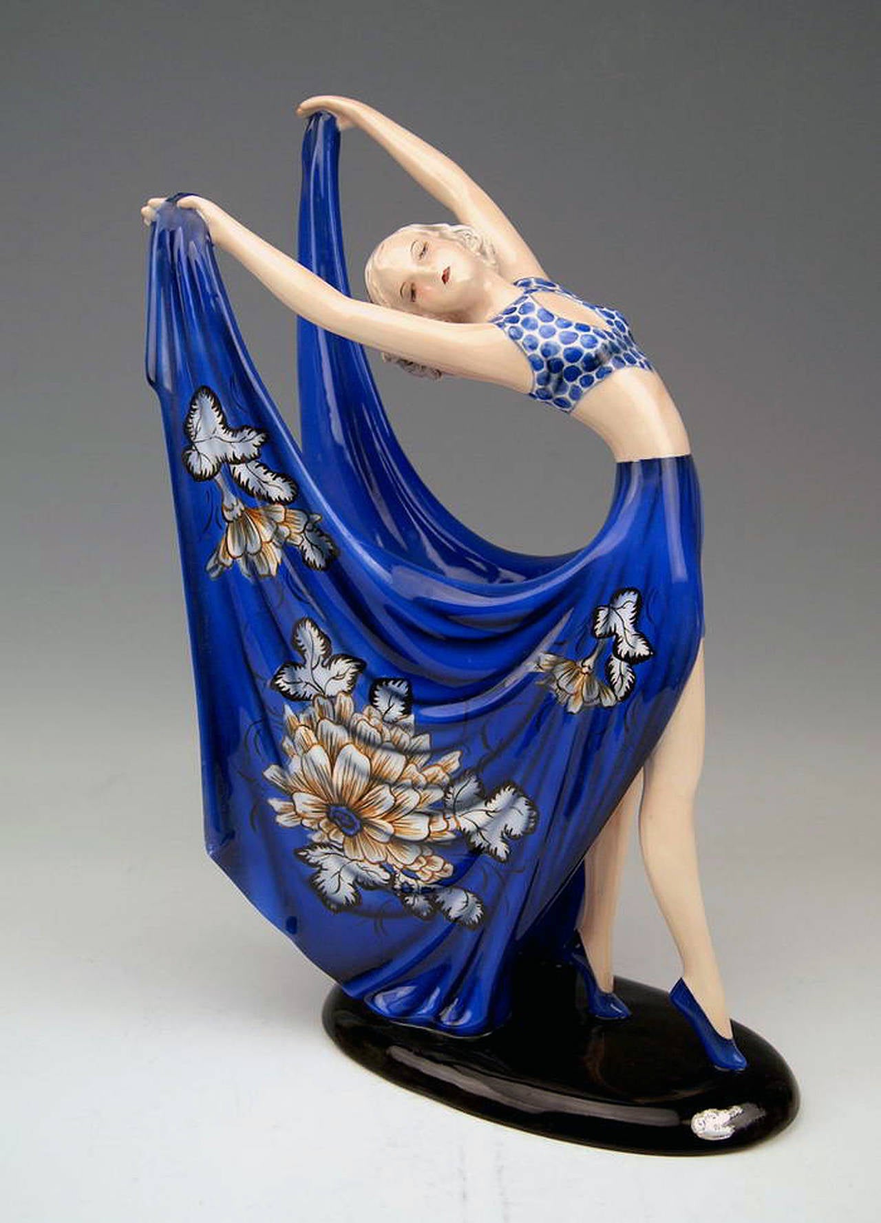GOLDSCHEIDER VIENNA DANCING LADY WEARING COBALT BLUE DRESS

Designed by Stefan  (= Stephen)  Dakon  (1904 - 1992), 
circa 1935    |   made 1938.  
model number 7195  /  1804  /  6

HALLMARKED:
Goldscheider WIEN ( = VIENNA) stamp mark
Made in