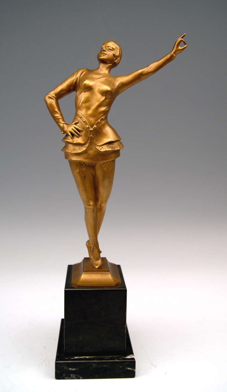 A finest Viennese Art Deco Bronze / Lady Dancer designed by modeller Ernst Beck (1879 - 1941): The woman clad in short girdled dancing dress  (tight-fitting jacket and pants as well as short skirt)  balances on tiptoes. The figurine’s left arm is