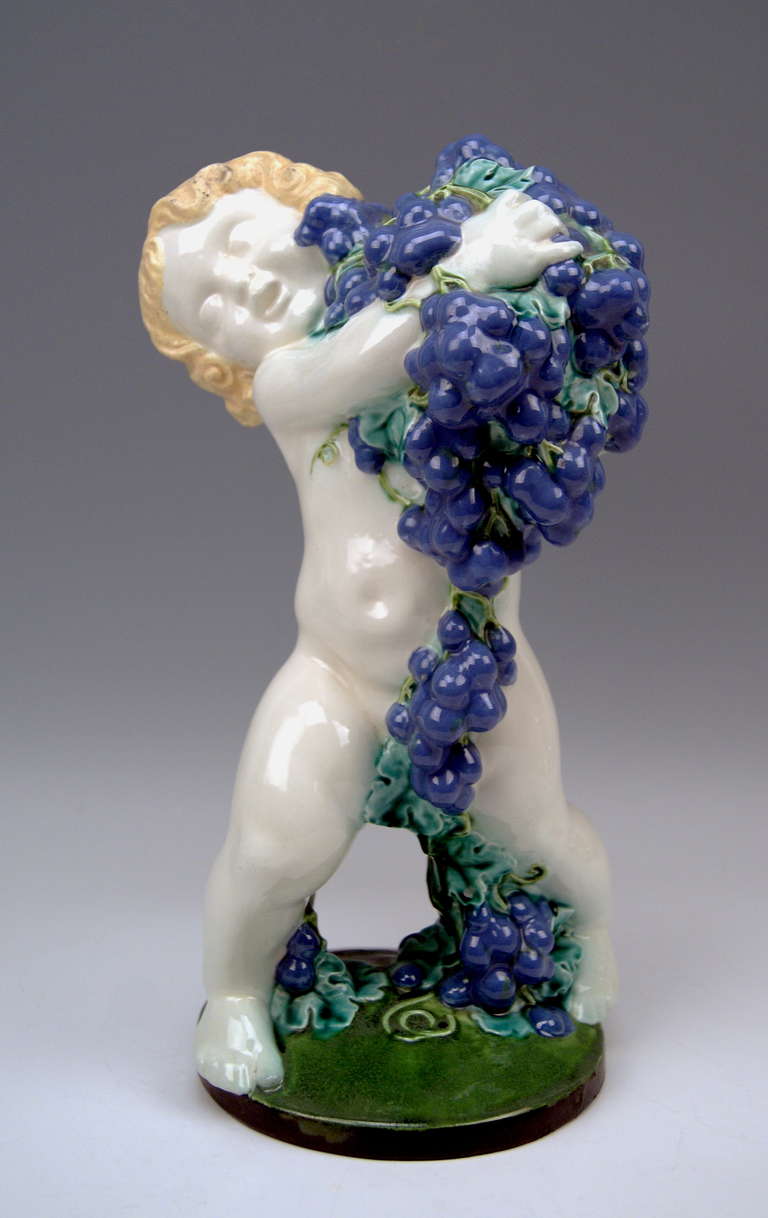 Jahreszeitenfigur Herbst / Skulptur eines lieblichen Cherubs mit Weintrauben
Modell geschaffen von Michael Powolny (1871-1954)

 Gepunzt: 
 hERGESTELLT VON WIENER KERAMIK (WK / GEPUNZT:: MODELLNUMMER 61)
 SIGNIERT MP ( = MICHAEL POWOLNY) 
 MATERIAL