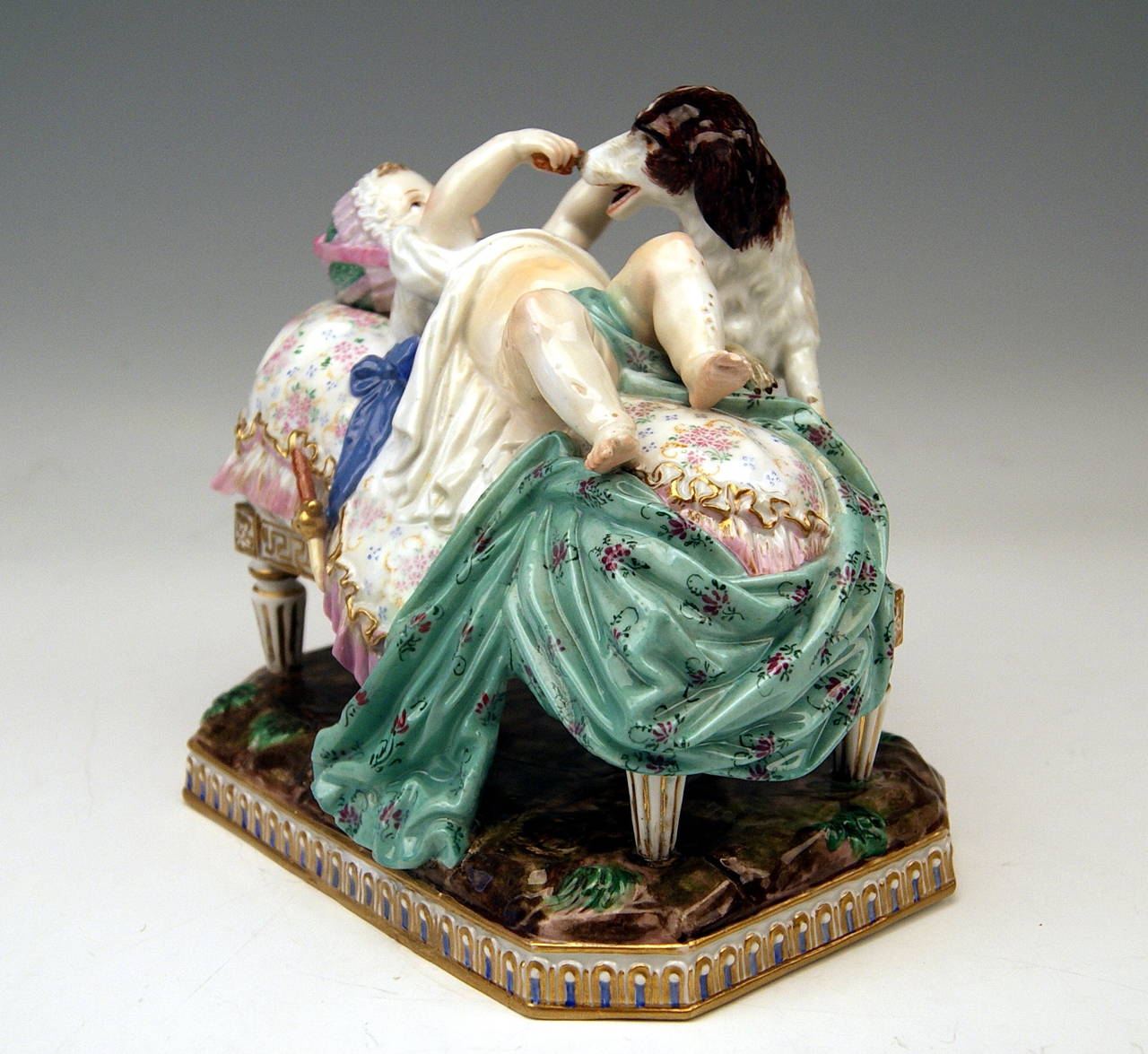 Groupe de figurines Meissen Gorgeous créé par Michel Victor Acier
(1736 - 1799)  vers l'année 1774 :  Plaisir de l'enfance

Spécifications :
Un adorable bébé est allongé sur une chaise longue rembourrée : Il joue avec
un chien s'appuyant sur le