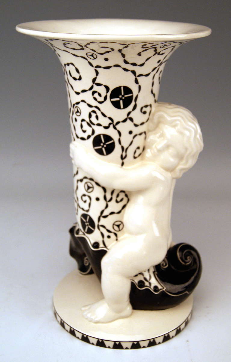 Sculptured most lovely Art Nouveau cherub clasping tall vase of cornucopia type, modeled by Michael Powolny (1871-1954)

Hallmarked:
Manufactured by Wiener Keramik (= Viennese Ceramics)
Material is ceramics (glossy finish and painted).
Model