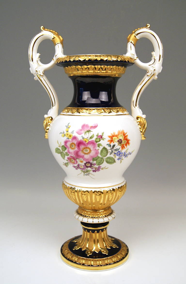 Meissen Tall Amphora Multicolored Vase With Two Handles /  Abundantly Painted With Flowers As Well As Partially Covered With Gold.  
made c. 1950
Neo - Empire Style,  possibly designed by Leuteritz  (circa 1860).
 
The vase is manufactured in