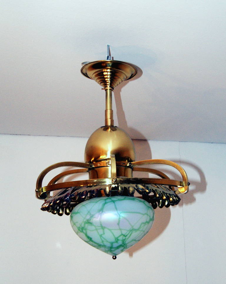 Superb Art Nouveau chandelier with finest glass shade made in Bohemia, circa 1900.
The bulb is enclosed by large  roundish glass shade (casing glass) of most remarkable appearance: the white-blue iridescent glass is decorated with green threads