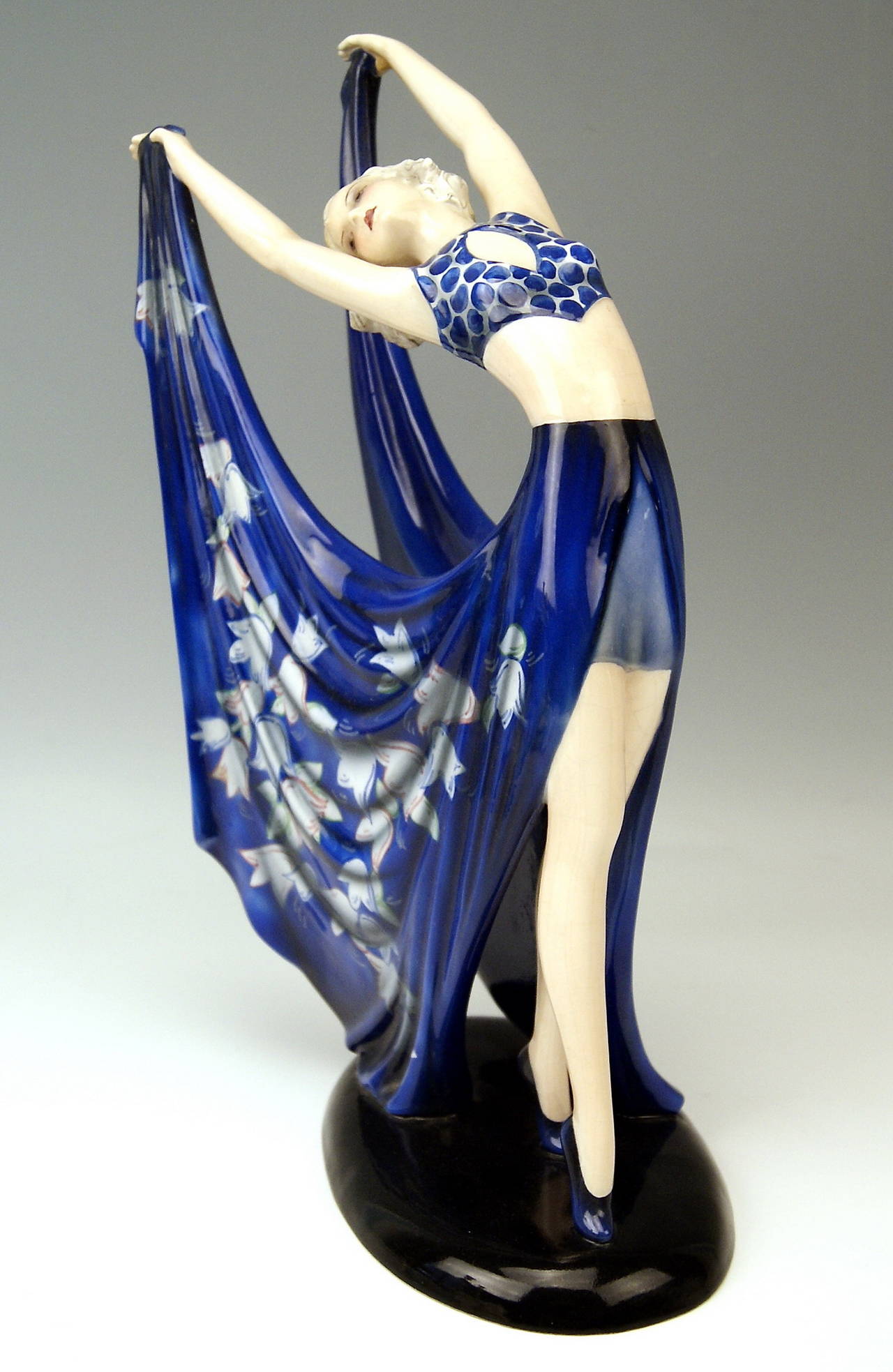 GOLDSCHEIDER VIENNA DANCING LADY WEARING COBALT BLUE DRESS

Designed by Stefan (= Stephen) Dakon  (1904 - 1992), 
circa 1935    |   made 1935/36.  
model number 7195  /  143  /  19

HALLMARKED:
Goldscheider WIEN ( = VIENNA) stamp mark
Made