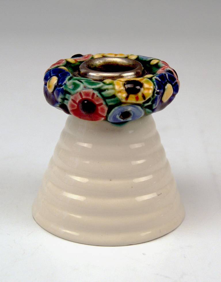 Elegant candlestick for holding one candle
Modelled by Michael Powolny (1871-1954), circa 1907

Hallmarked:
Manufactured by Wiener Keramik and Gmundner Keramik 
(union Of Vienna Ceramics & Gmunden Ceramics - VWGK / Hallmarked)
Material is
