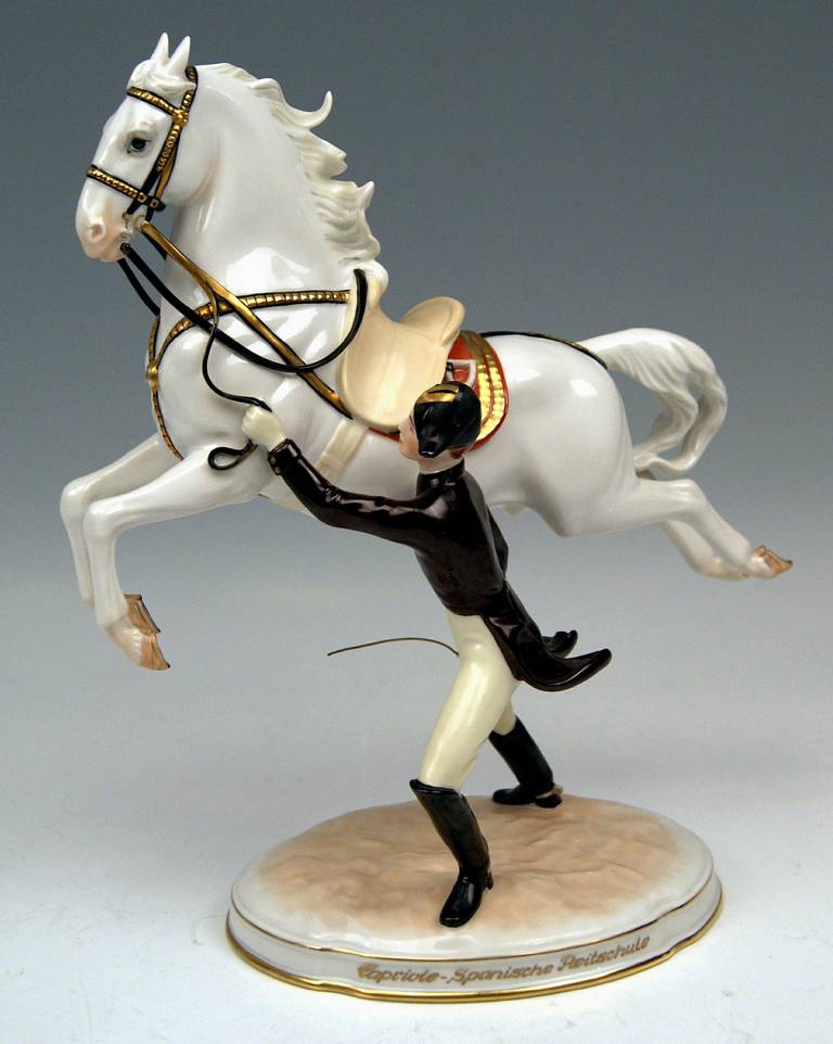 Vienna Augarten Horse Spanish Riding School
 Figurine Type:  Capriole

 The rider  -  conducting the horse by the reins  -  stands beside the jumping white Lipizzan; he seizes a cane which he needs for horse training. The jumping horse depicts a