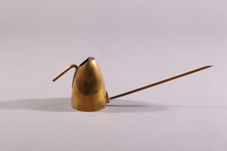 This mid-century modern watering can was handmade in brass by the masterful Viennese designer Carl Auböck (1900-57). 
It is stamped on the bottom with Auböck's last name as well as 