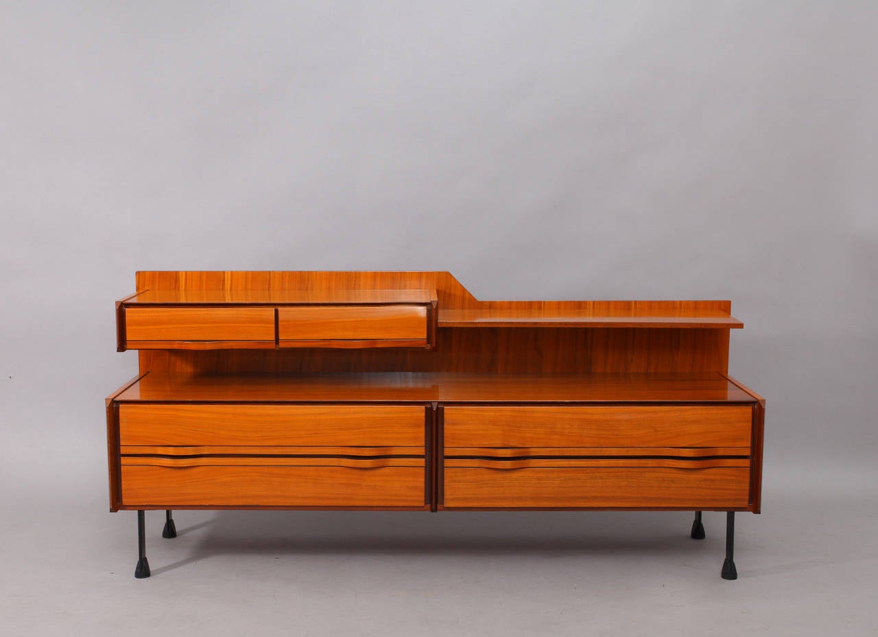 Italian Mid-Century Modern sideboard, La Permanente Mobili Cantu`, 1960, a beautifully designed, six drawer, teak wood sideboard with multiple level work areas, all raised on black lacquered steel legs with wood feet. Handles are formed from teak.