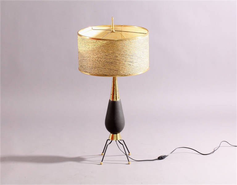 Table lamp,
USA, 1950s.
Brass legs, fabric shade.
Middle part ceramic and brass.
Measures: Height 33