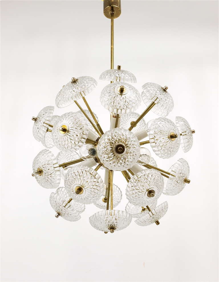 A very beautiful 1960s brass chandelier from Italy. Made of brass with stylish flower-like glass light diffusers. In good condition with nice patina on the brass. Has 10 sockets, no damages on the glasses. Makes a wonderful light.

total height