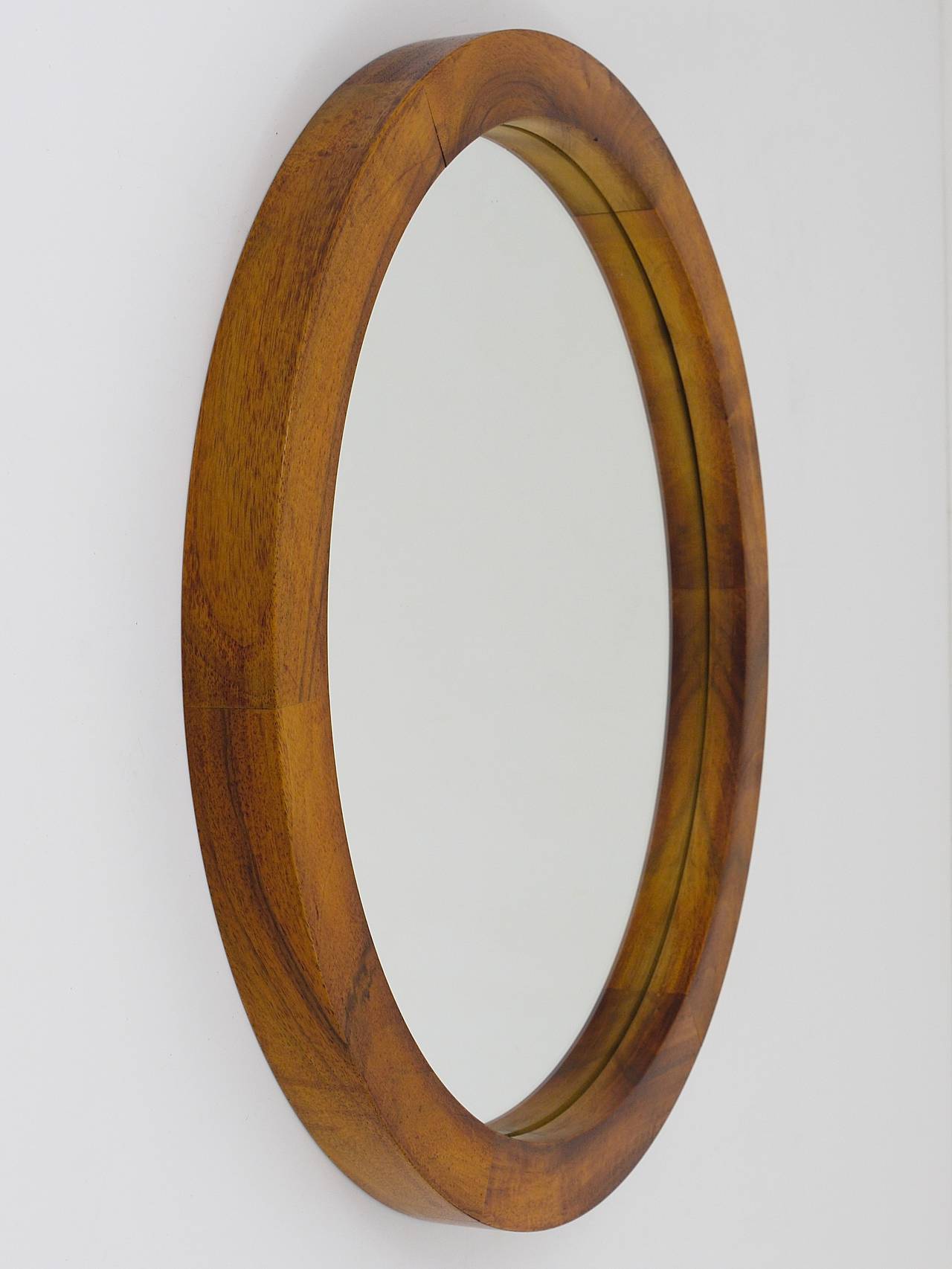A beautiful modernist round wall mirror, designed and executed by Carl Aubock, Vienna, in the 1950s. The mirrors frames is made of walnut wood. Diameter 18