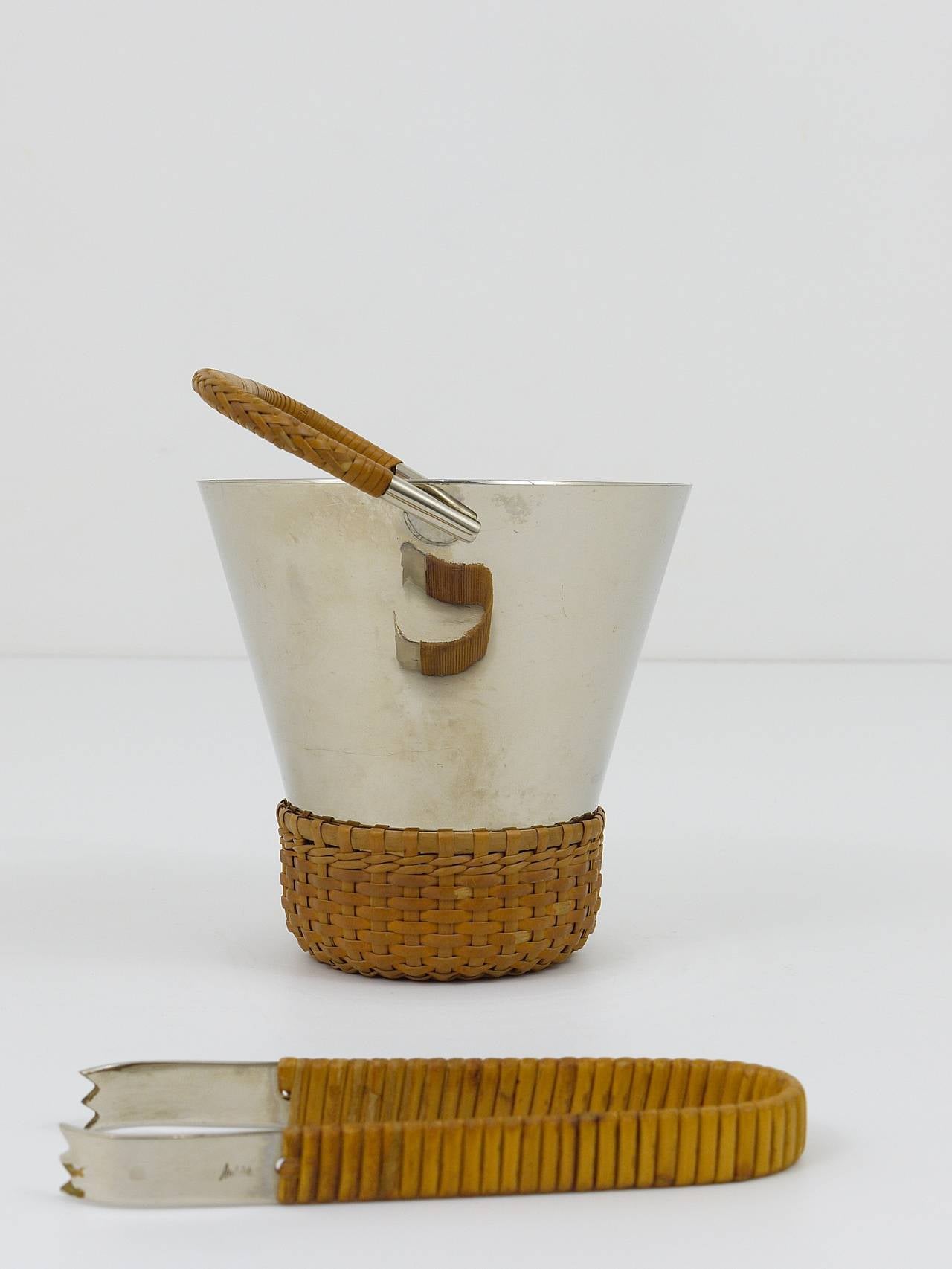A beautiful modernist ice bucket and tongs, designed and executed by Carl Aubock, Vienna,  in the 1950s. Made of nickel-plated brass with nice wicker. In good condition with charming patina. height with handle: 7