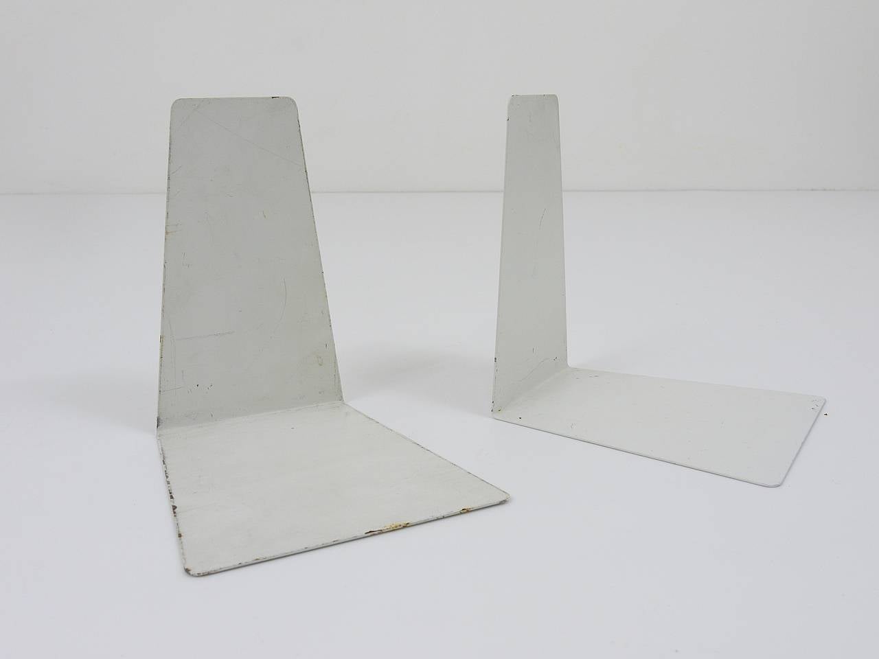 A beautiful pair of white Bauhaus bookends, made of metal, dated around 1930, designed by Marianne Brandt, executed by Ruppel Werke, Gotha, Germany. In good condition, charming size of age. Marked. We offer an identical pair of bookends, but in