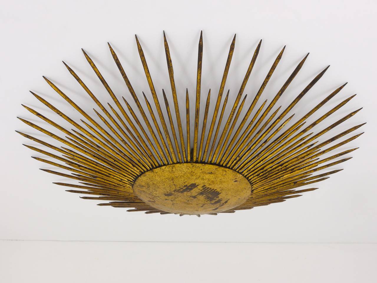 A very beautiful sunburst flush-mount ceiling lamp, made of gilded metal. Made in France in the 1950s, in very good condition, with charming patina. Diameter 29