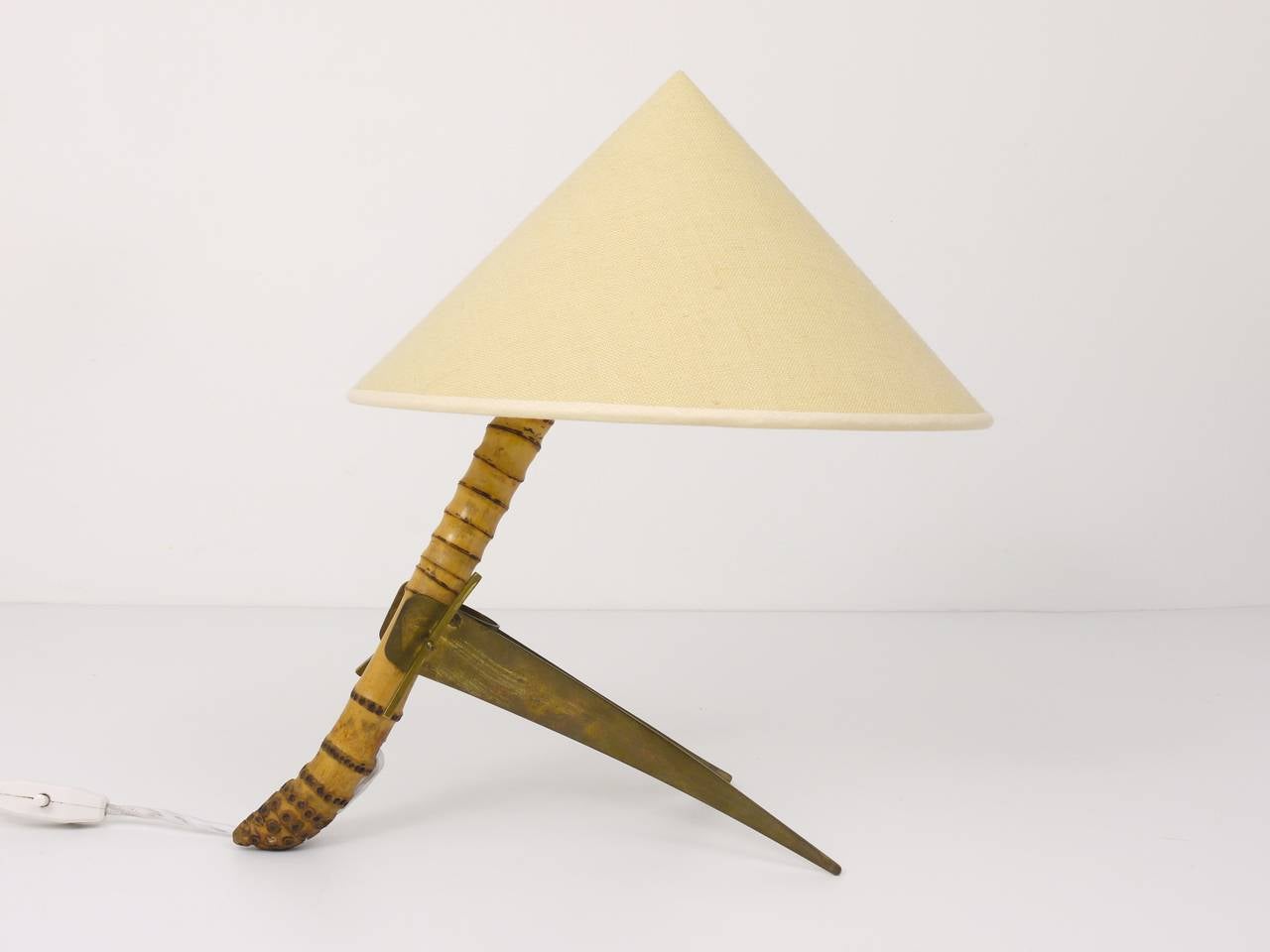 A beautiful modernist table lamp from the 1950s, executed by Rupert Nikoll Austria. Has a beautiful bamboo neck and a two-leg brass base and its original, refurbished lampshade. In good condition with nice patina on the brass.