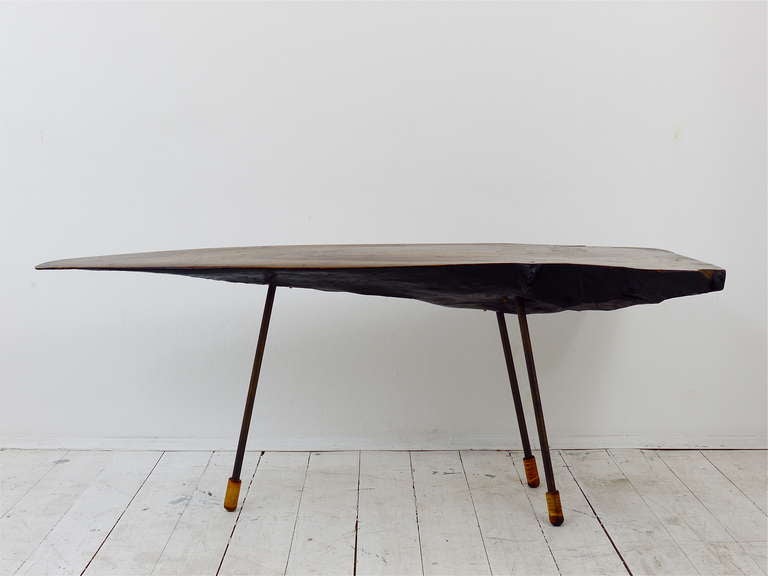 A very unusual and long Viennese tree trunk table, designed and executed by Carl Aubock in the 1950s. Made of a walnut wood slab, black painted bottom, with three brass legs with wooden shoes. In original unrestored condition with normal signs of