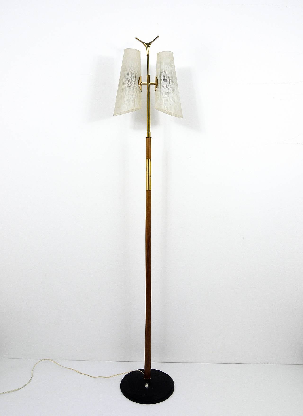 Un magnifique lampadaire moderniste viennois, conçu et exécuté par Rubert Nikoll dans les années 1950. Elle possède une base en fonte noire, une tige en bois, de jolis détails en laiton, de jolis abat-jour en verre rayé et un charmant plateau en