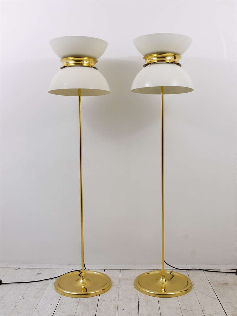 A pair of exceptional Italian Mid-Century floor lamps from the 1950s, made of brass with white painted metal lampshades. In excellent condition, have been gently restored and rewired. The lampshades have still there original lacquering, please