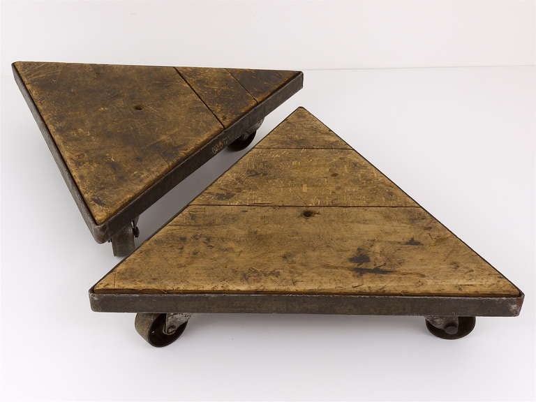 A matching pair of unique 70-year-old industrial wheel boards, made in France. Triangular, very decorative, made of iron and wood. Both boards have ball-bearing wheels and are rolling very smoothly. May be used as  flower stands, but also as movable