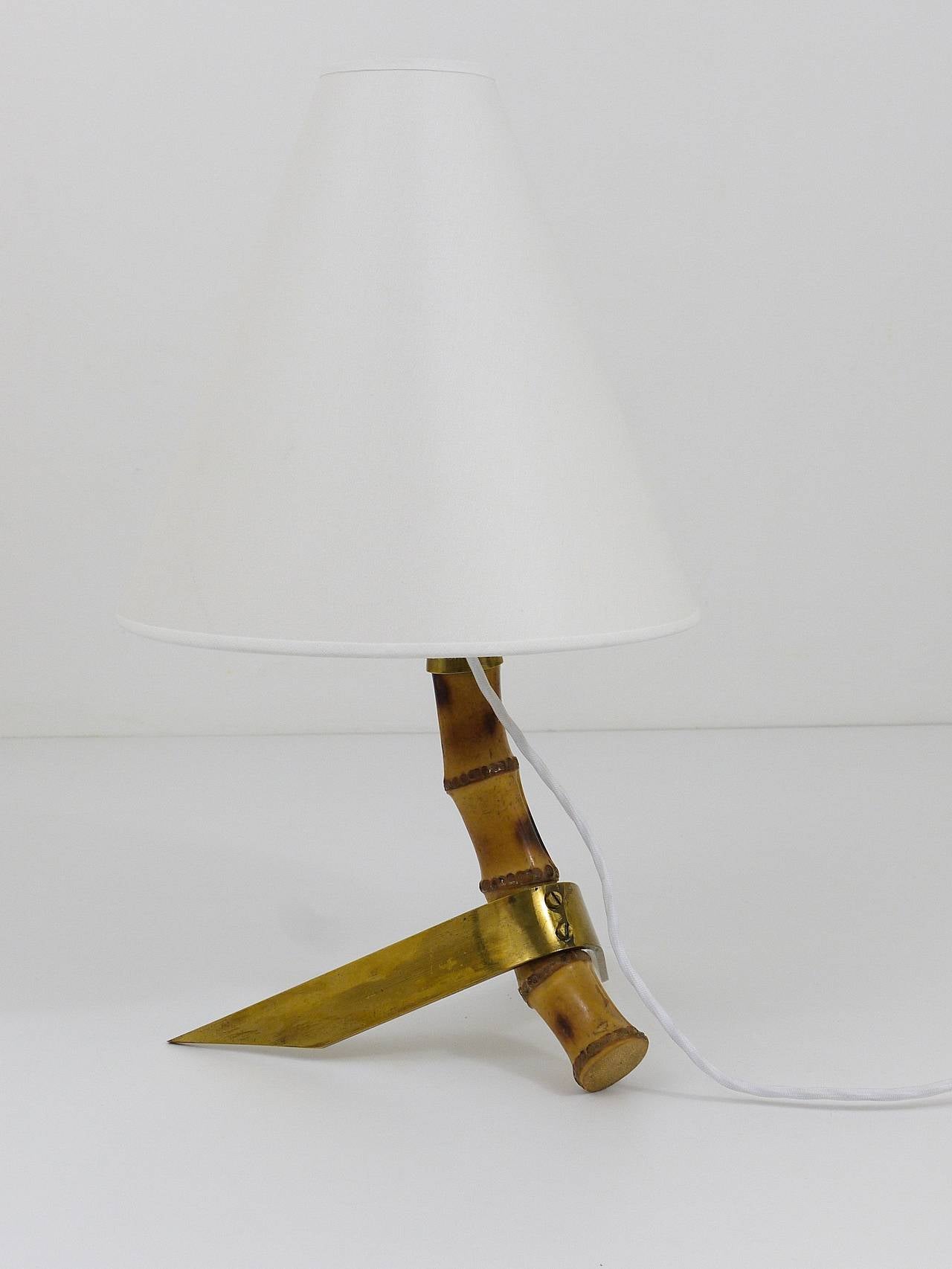 A very beautiful modernist table lamp from the 1950s, executed by Rupert Nikoll Austria. Has a beautiful bamboo neck and a two-leg brass base and its original, refurbished lampshade. In good condition with nice patina on the brass.